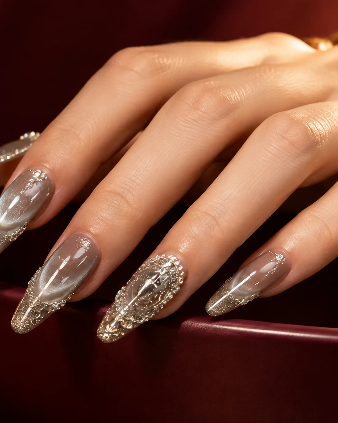 Silver glitter press-on nail set on a burgundy surface